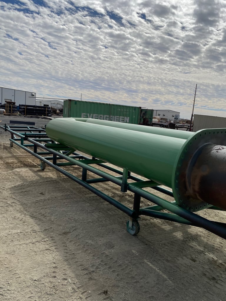 Large green industrial storage tank on trailer bed in shipping yard with containers and cloudy sky